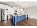 Modern kitchen featuring stainless steel appliances, white cabinets, and a blue center island with barstool seating at 135A Sunset Dr., Murrells Inlet, SC 29576