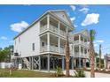 Stunning elevated beach home with dual balconies, covered parking, and well-maintained landscaping at 135B Sunset Dr., Murrells Inlet, SC 29576