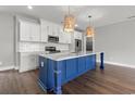 Modern kitchen featuring bright white cabinets, sleek countertops, a navy blue island, and pendant lights at 135B Sunset Dr., Murrells Inlet, SC 29576