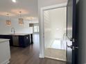 View into living room and kitchen area, featuring hardwood floors and modern pendant lighting at 135B Sunset Dr., Murrells Inlet, SC 29576