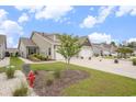A cozy home with a manicured lawn, featuring a two-car garage and attractive landscaping at 1807 Berkley Village Loop, Myrtle Beach, SC 29579