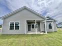 A beautiful backyard featuring a covered patio, green lawn and a gray exterior siding at 185 Norris Ln, Loris, SC 29569