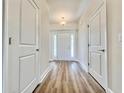Inviting hallway featuring wood-look floors, white trim, and a decorative light fixture at 185 Norris Ln, Loris, SC 29569
