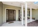 Inviting front porch with seating area and decorative front door at 2080 Highway 915, Loris, SC 29569