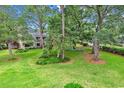Serene backyard featuring sprawling green lawn, mature trees and foliage offering a tranquil escape at 213 Westleton Dr. # 16-D, Myrtle Beach, SC 29572