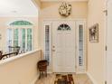 Bright foyer with decorative door, sidelights, tiled floor and beautiful decorative wreath at 24 Gate 7, Carolina Shores, NC 28467