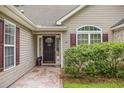 Inviting front entrance featuring a decorative walkway, tasteful landscaping, and stylish front door at 24 Gate 7, Carolina Shores, NC 28467