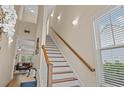Bright staircase with white risers, wood treads, a wooden handrail, and natural light at 309 Foxpath Loop, Myrtle Beach, SC 29588