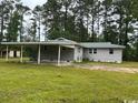 A side view of the home showing a well-maintained yard and attached carport at 321 Circle Heights Dr., Loris, SC 29569