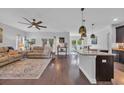 Open concept living room featuring hardwood floors, ceiling fan, and cozy tan leather sofa at 321 Sanctuary Ct., Myrtle Beach, SC 29588