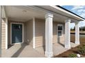 Inviting front porch with elegant white columns and a stylish blue door at 3558 Ashridge Way, Conway, SC 29526