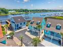 Aerial view of charming homes with a waterway view, boat docks, lush landscape and ample parking at 4534 Landing Rd., Little River, SC 29566