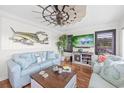 Living room with nautical decor, wood floors, blue sofa and chairs, and a decorative windmill fan at 4534 Landing Rd., Little River, SC 29566