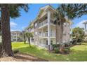 Exterior condo with brick facade, balconies, and lush green space at 4721 Hibiscus Dr. # 3-302, Little River, SC 29566