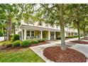 Inviting exterior view showcasing the covered front porch with classic rocking chairs and lush landscaping around the home at 4901 N Market St., North Myrtle Beach, SC 29582