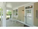 Relaxing front porch featuring rocking chairs, a stylish front door, and pleasant natural light at 4901 N Market St., North Myrtle Beach, SC 29582