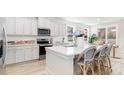 Bright, open kitchen with stainless steel appliances, white cabinets, and a large island with seating at 506 Haven View Way, Murrells Inlet, SC 29576