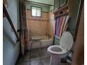 Classic bathroom with tiled walls, a tub with seat, and fixtures in need of repair at 564 Baker Ave., Murrells Inlet, SC 29576