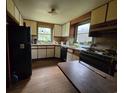 Traditional kitchen with white cabinets, wood trim, black appliances, and worn hardwood floors at 564 Baker Ave., Murrells Inlet, SC 29576