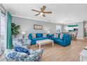 Comfortable living room with bright blue sofas, floral armchairs, and a ceiling fan at 5825 Catalina Dr. # 125, North Myrtle Beach, SC 29582