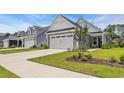 View of a well-kept lawn and manicured landscaping leading up to the charming home at 598 Cascade Loop, Little River, SC 29566