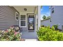 Cozy front porch with decorative plants, charming bench, and welcoming decor at 598 Cascade Loop, Little River, SC 29566
