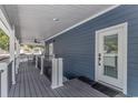 Covered porch features exterior door, ceiling fan, composite decking, and white railing at 6001- Q10 S Kings Hwy., Myrtle Beach, SC 29575