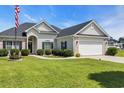 Traditional single-story home featuring a lush green lawn and a two-car garage at 605 Fieldwoods Dr., Conway, SC 29526