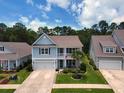 An aerial view of a two-story home with a two-car garage, set amongst mature trees and manicured lawns at 748 Old Murrells Inlet Rd., Murrells Inlet, SC 29576