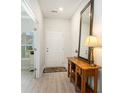 Entryway with a wooden table, a large mirror, and view to sunlit office space with hardwood floors at 775 Harrison Mill St., Myrtle Beach, SC 29579