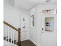 Bright entryway featuring shiplap walls, wood-look floors, and a staircase, offering a welcoming introduction to the home at 866 Fowler Rd., Conway, SC 29526