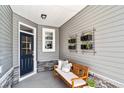 Inviting front porch with a wooden bench, stylish planters, and a blue front door, creating a cozy entrance at 866 Fowler Rd., Conway, SC 29526