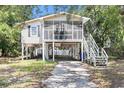 Charming stilt home featuring a screened porch and driveway at 910 N Dogwood Dr., Surfside Beach, SC 29575