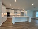 Bright kitchen boasts white cabinets, stainless steel appliances, and center island with counter seating at 924 Lady Bird Way, North Myrtle Beach, SC 29582