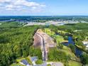 Expansive aerial view of a community development site surrounded by lush green forests and a serene golf course at 9734 Indigo Creek Blvd., Murrells Inlet, SC 29576