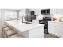 Modern kitchen features stainless steel appliances, white cabinets, and a large center island at Ryegrass Way # 0029F, Murrells Inlet, SC 29576