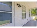 View of a porch featuring a white exterior, light fixture, windows, and fresh paint at 10071 Kings Rd., Myrtle Beach, SC 29572