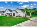 Relax outside with a porch swing surrounded by mulch beds and palm trees on a spacious lawn at 101 Karlie Ln., Aynor, SC 29511