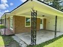 Spacious carport featuring decorative metal support pillars with access to a side entrance and backyard at 109 S Maple Ave., Andrews, SC 29510