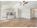 Bright open-concept living space with vaulted ceiling, ceiling fan and wood-look flooring at 1107 Woodside Dr., Conway, SC 29526