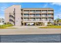 Exterior shot of the condo building, featuring a covered parking area, outdoor staircases, and individual balconies at 120 Dogwood Dr. N # 313, Garden City Beach, SC 29576