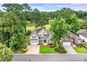 Stunning aerial view of a home nestled in a lush, wooded community with a golf course and lake nearby at 124 Turtle Creek Dr., Pawleys Island, SC 29585