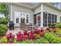 Cozy patio with wicker furniture, a grill, and vibrant flowers, perfect for outdoor entertaining and relaxation at 124 Turtle Creek Dr., Pawleys Island, SC 29585