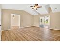 Bright living room featuring wood floors, ceiling fan, and a vaulted ceiling with access to the patio at 131 Pine Lake Circle, Ocean Isle Beach, NC 28469