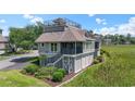 This lovely two-story home features lush landscaping, stylish stairs, and charming architectural details at 1663 Harbor Dr., North Myrtle Beach, SC 29582