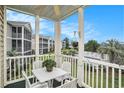 Relaxing screened balcony with table, chairs, and views of community pool and landscaping at 2000 Cross Gate Blvd. # 202, Surfside Beach, SC 29575