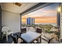 Balcony with a glass table, four chairs and a beautiful view of the beach at 2000 S Ocean Blvd. # V405, Myrtle Beach, SC 29577