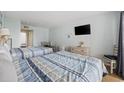 Bedroom featuring two beds, TV, dresser, and adjacent dining area at 2000 S Ocean Blvd. # V405, Myrtle Beach, SC 29577