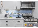 Efficient kitchen offers white cabinets, marble countertops, stainless appliances, and a tiled backsplash at 2001 S Ocean Blvd. # 1408, Myrtle Beach, SC 29577