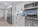 Cozy kitchen features stainless steel appliances, white cabinetry, and blue tile backsplash at 2001 S Ocean Blvd. # 1408, Myrtle Beach, SC 29577